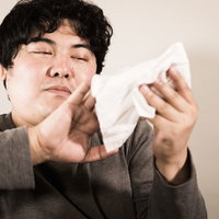 布に包んだやわらかスマホを手に持つ男性の写真