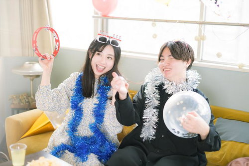 タンバリンを持って若い男女が2人でホームパーティーを楽しむ