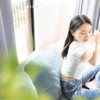白いソファでストレッチする女性の写真