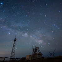 天の川と鉄塔のシルエットが対比する夜空の星景の写真