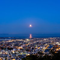 徳島の夜景と満月が照らす夜空の写真