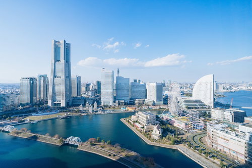 青空に映るみなとみらいランドマークタワーとコスモワールドの景観