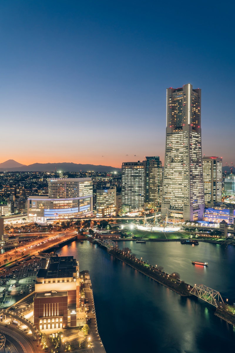 夕暮れ時の横浜みなとみらい地区の高層ビル群と水辺の風景