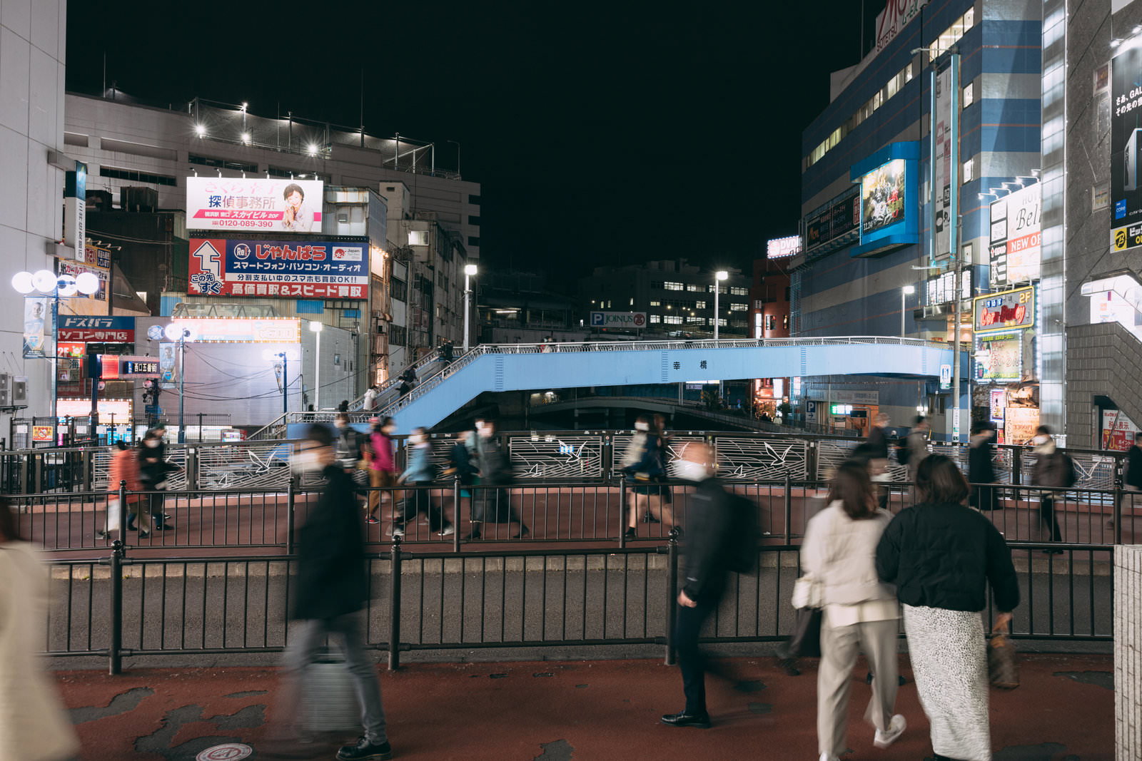 夜の南幸橋で行き交う人々と周囲の明るい街並み