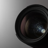 カメラレンズに付着した水滴と結露の痕跡、湿気による曇りと光の屈折の写真