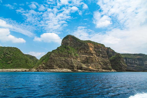 船上から撮影した徳之島の縞状地層が露出する断崖絶壁