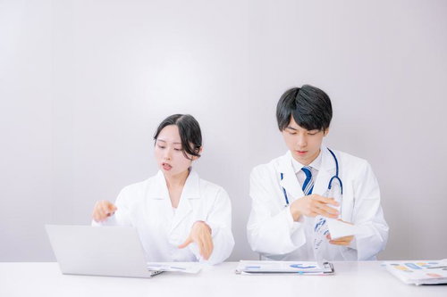 デスクでカルテを確認しながら説明する医師たち