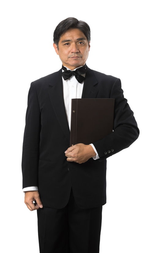 メニューを持った中年のウェイター、黒いタキシード姿でサービス