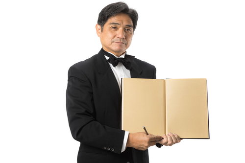 メニューを見せる執事風の中年男性ウェイター