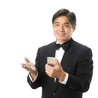 スマホで宿泊予約を確認するホテルマンの案内の写真