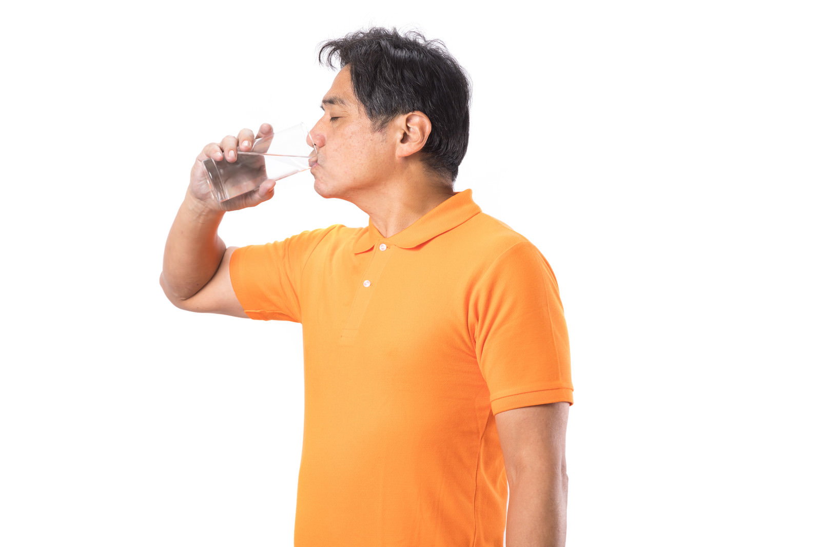オレンジ色のTシャツを着た中年男性がペットボトルから勢いよく水を飲んでいる［モデル：よたか］