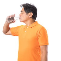 ペットボトルから勢いよく水を飲む中年男性の写真