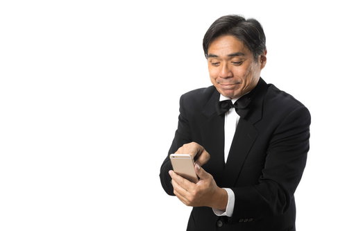 苦手なスマートフォンを使う中年執事の操作風景