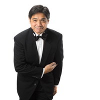 お待ちしておりました。ウェイター姿で腕組みする男性の写真