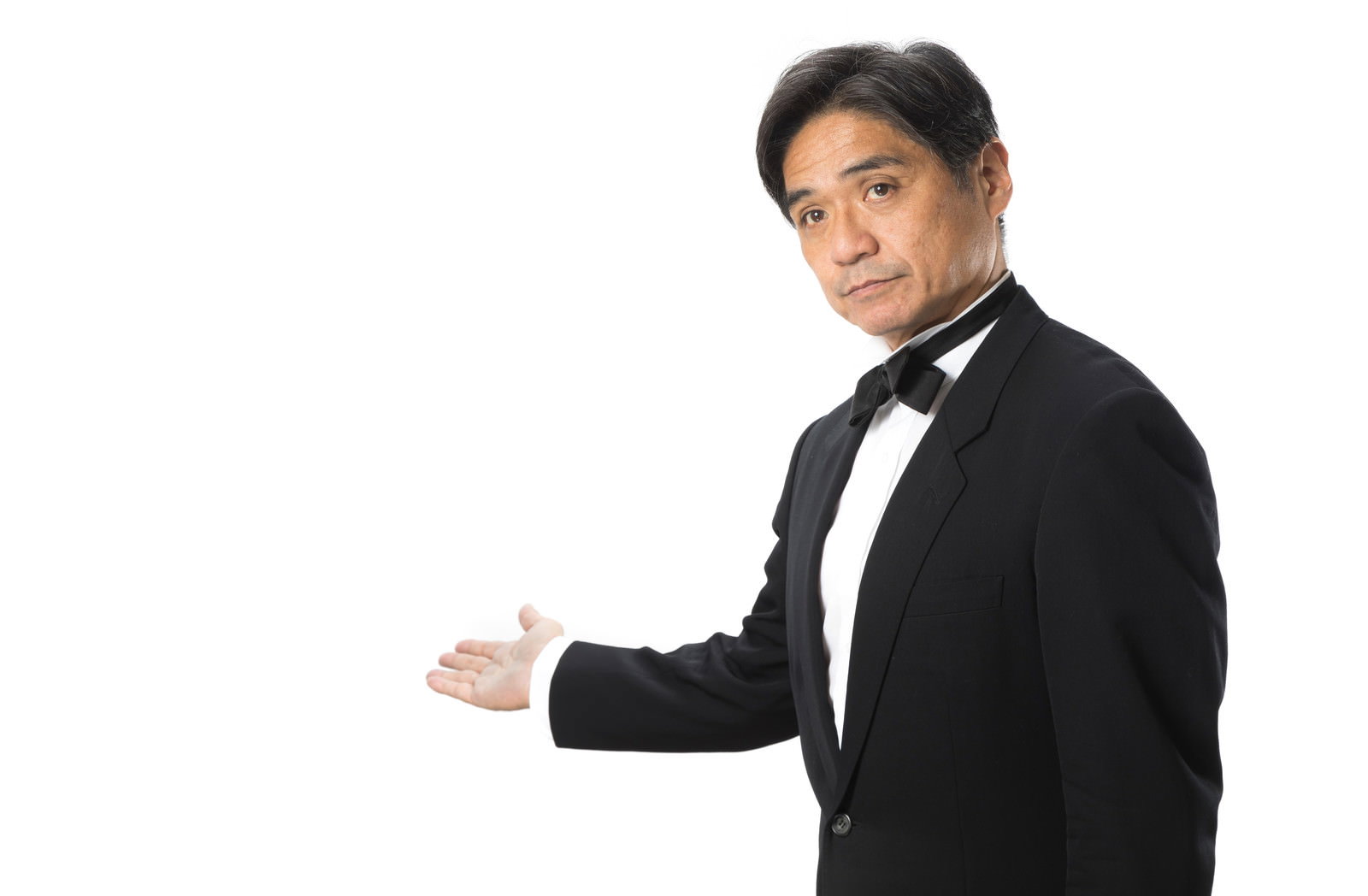 黒いスーツを着た男性が右手を差し出して案内をしている［モデル：よたか］