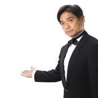 お帰りはあちらです。と案内する執事姿の男性の写真