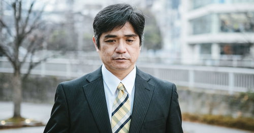 疲れが顔に出てきた部長職の男性会社員のビジネスポートレート