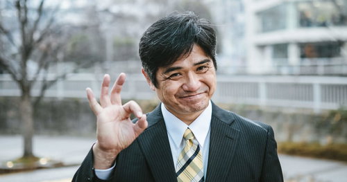 ニコニコスマイルでオッケーサインを出す部長