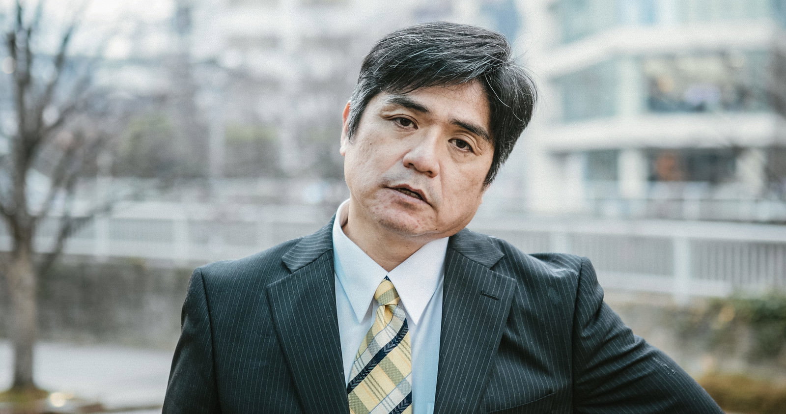 スーツ姿の男性上司が落胆した表情でため息をついている様子［モデル：よたか］