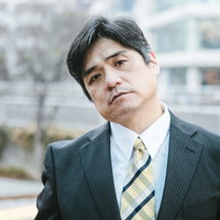 他人の話に興味がない中年男性の表情と視線の写真