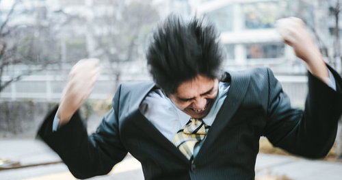 激しく怒る中年部長がスーツ姿で両手を上げた姿
