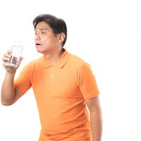 脱水症気味の中年男性がミネラルウォーターで水分補給の写真