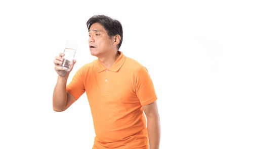 脱水症気味の中年男性がミネラルウォーターで水分補給