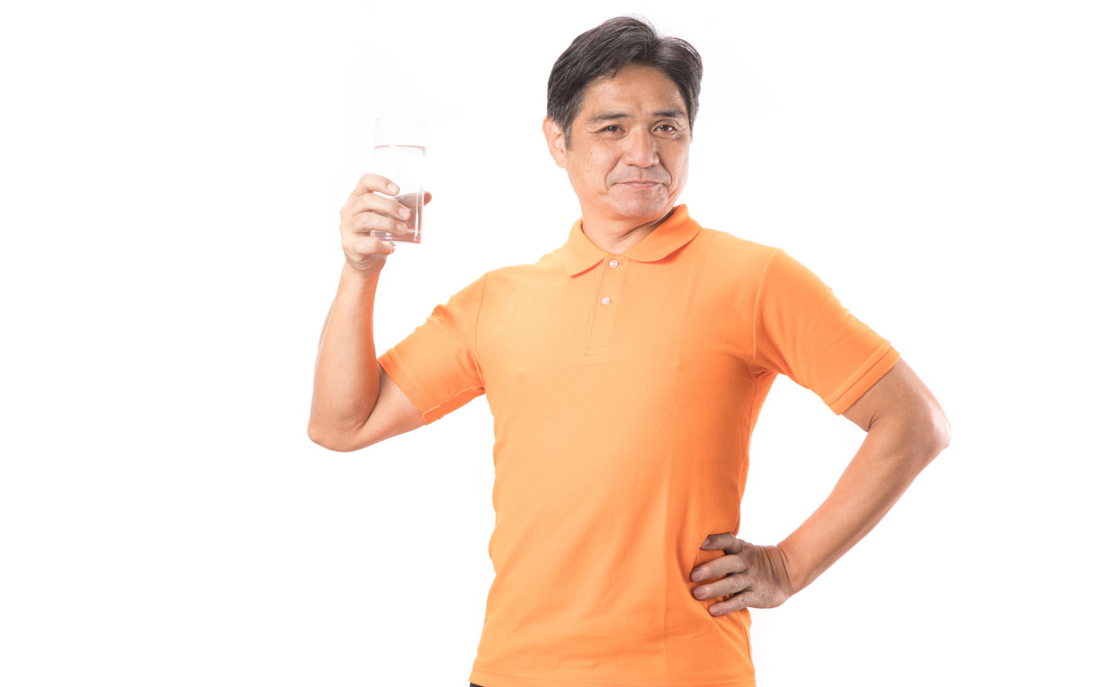 オレンジ色のTシャツを着た男性がペットボトルを持って水分補給するポーズ［モデル：よたか］