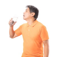 ペットボトルの水を飲む夏バテ気味の中年男性の写真