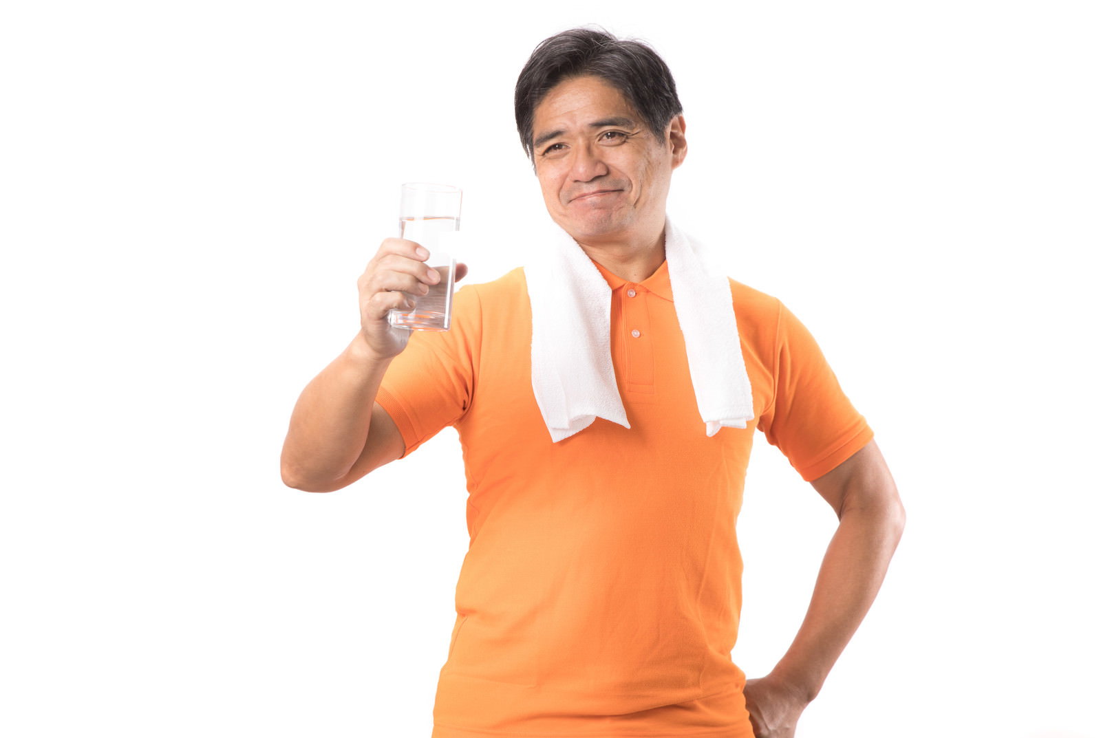 オレンジ色のシャツを着てタオルを首にかけた中年男性が水分補給している［モデル：よたか］