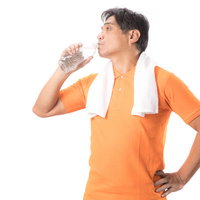 こまめにペットボトルの水を飲むランニング中のお父さんの写真