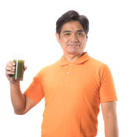 青汁を片手に持った中年男性が健康的な笑顔で栄養補給の写真