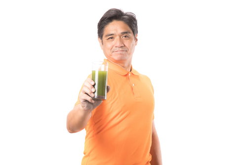 青汁を飲んで生き生きとしている中年男性のポートレート