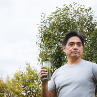 青汁を手に持つ中年男性の健康的なライフスタイルの写真