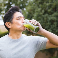 青汁ゴクゴク！飲む中年男性の健康的なライフスタイルの写真
