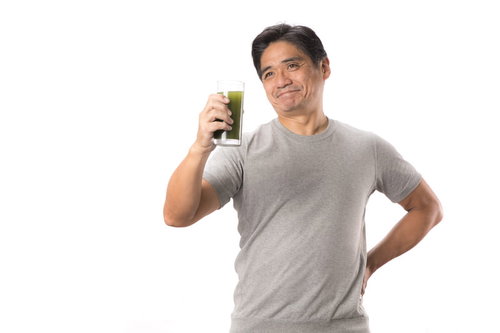 青汁が入ったコップを片手に笑顔のお父さん