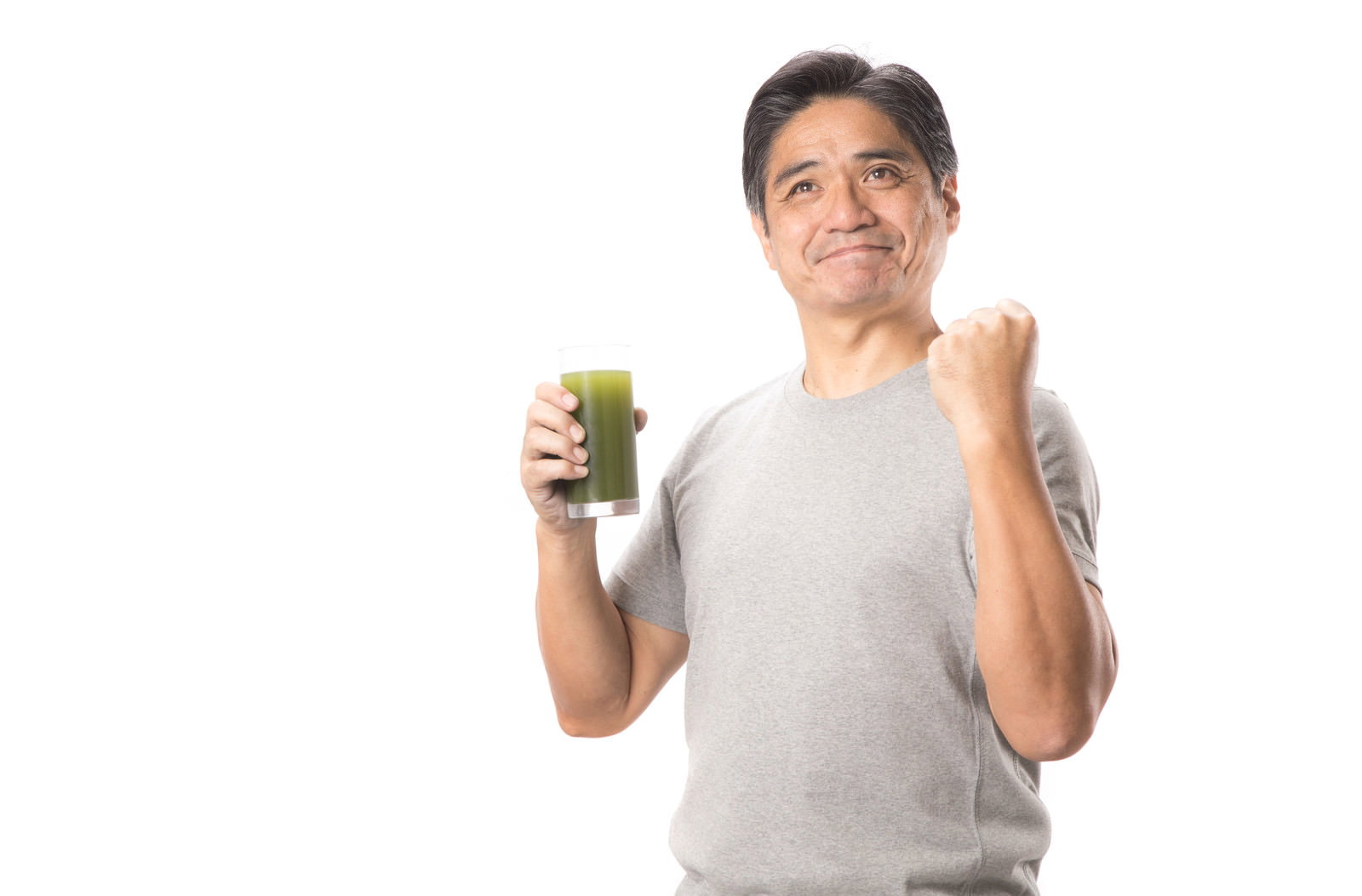 青汁を持ってガッツポーズをする笑顔の中年男性［モデル：よたか］