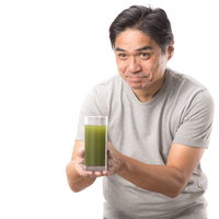 搾りたての青汁を持つ中年男性の健康的なライフスタイルの写真