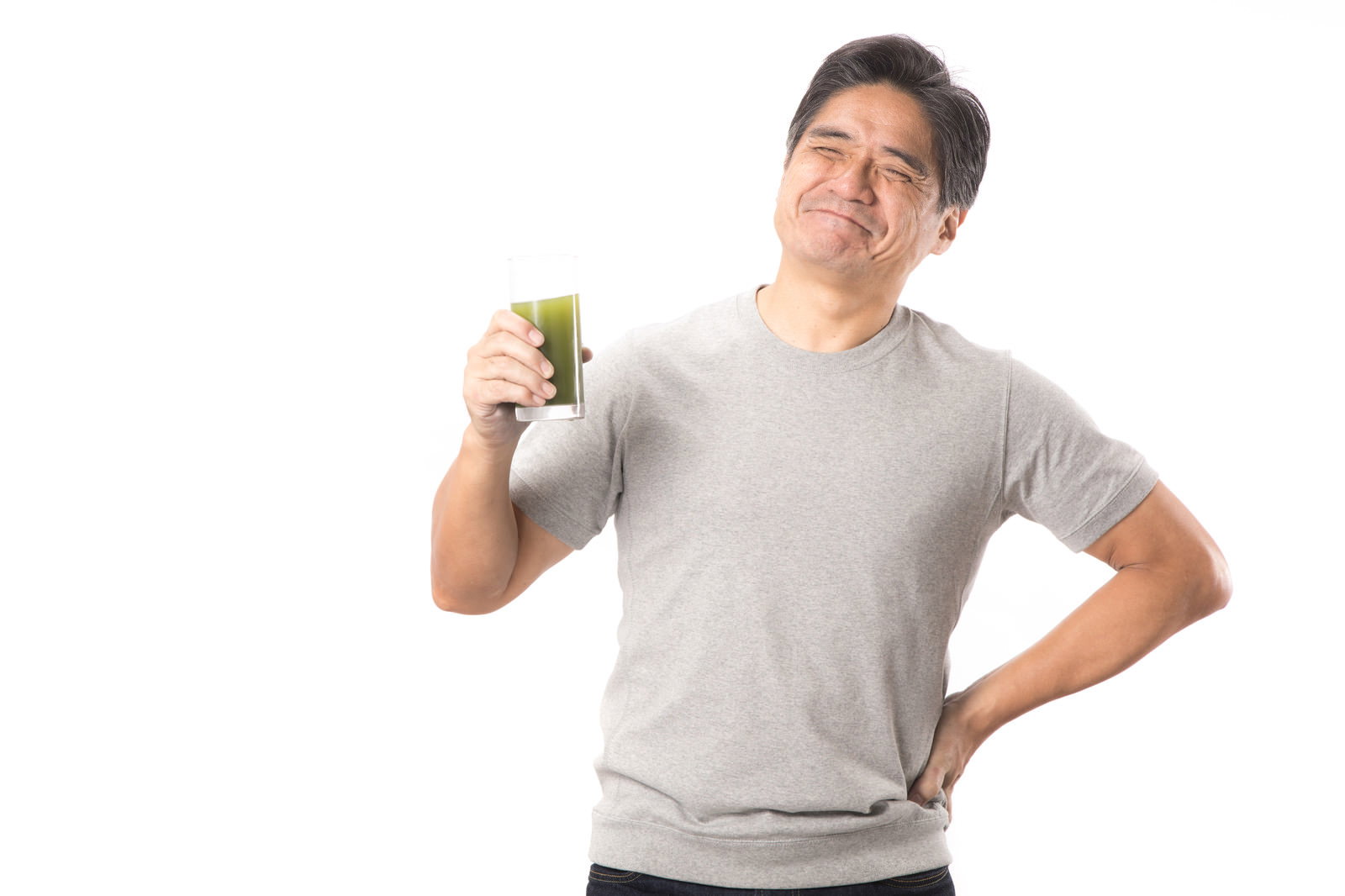 青汁を手に持ち笑顔を見せる中年男性［モデル：よたか］