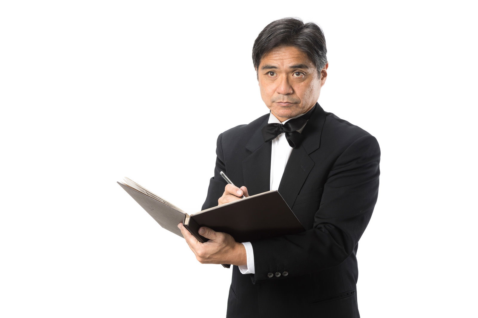 白い背景で手帳にメモを取る黒いスーツを着た男性［モデル：よたか］