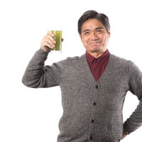 私の元気の秘密はこの青汁です！グラスを持つ健康的な中年男性の写真