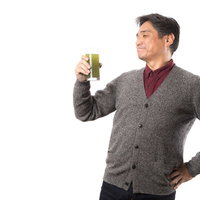 グラスの青汁を飲んでご満悦な男性の健康的な笑顔の写真