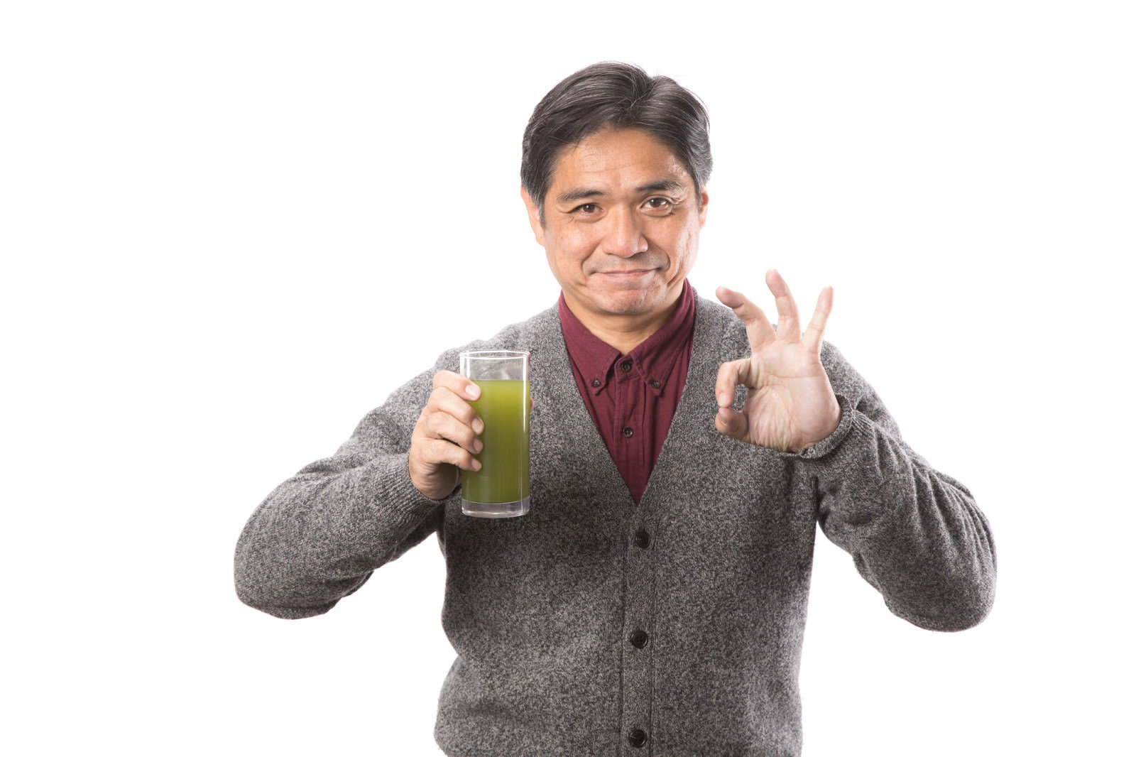 青汁のグラスを持ちながら親指を立ててグッドサインをする中年男性［モデル：よたか］