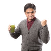 青汁を飲んで元気だしてこ！ガッツポーズする中年男性の写真