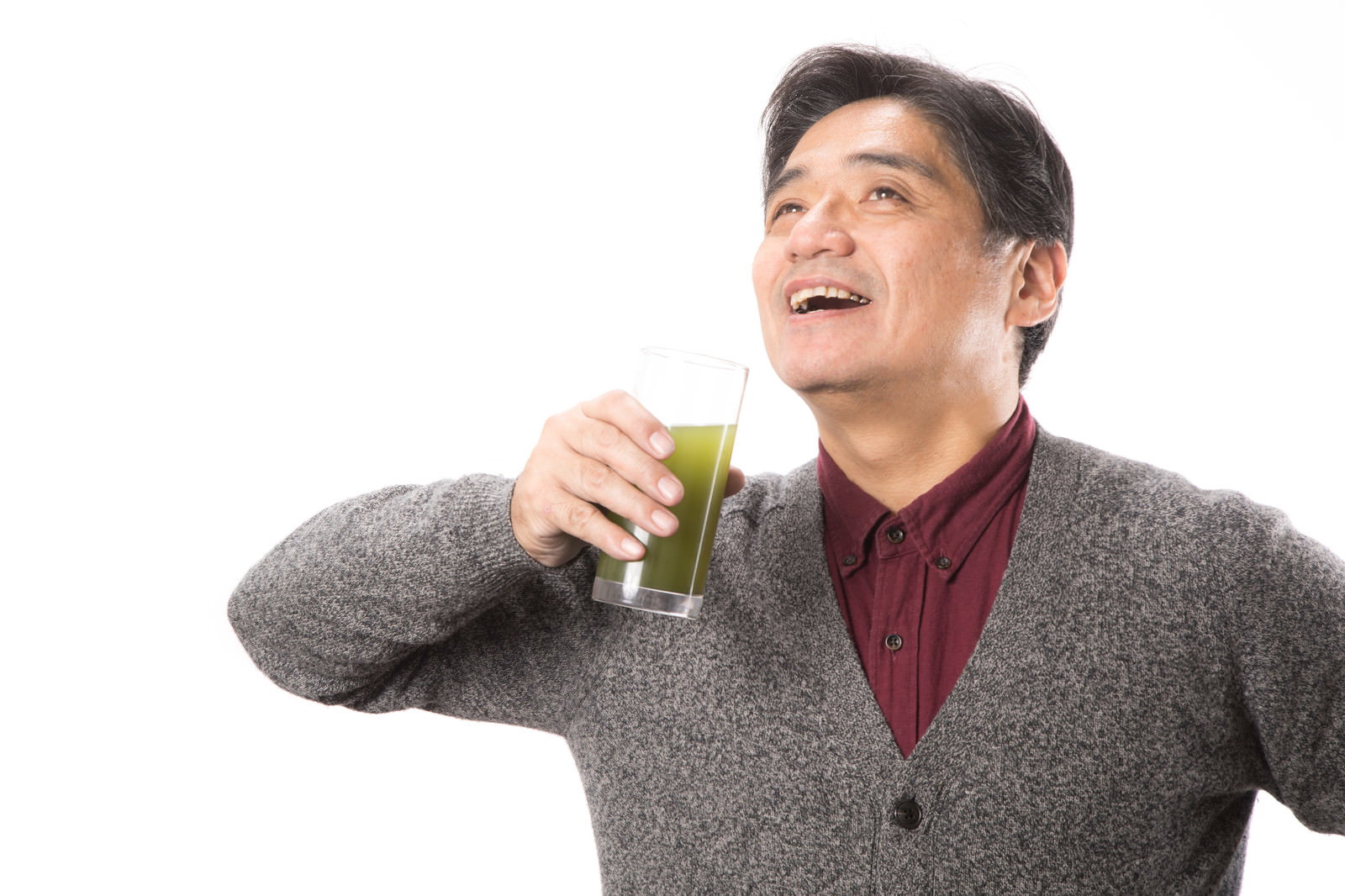 青汁を飲んで驚くガッツポーズの中年男性［モデル：よたか］