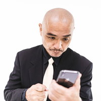 何度もスマホを見返してしまう坊主中年の写真