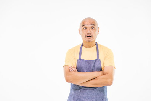 黄色いエプロン姿で驚き目を見開く坊主パパ