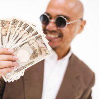 諭吉大好き、札束を手に持つサングラスの男性の写真