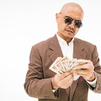 厳しい表情の取り立て人が万札を数える現金確認の写真