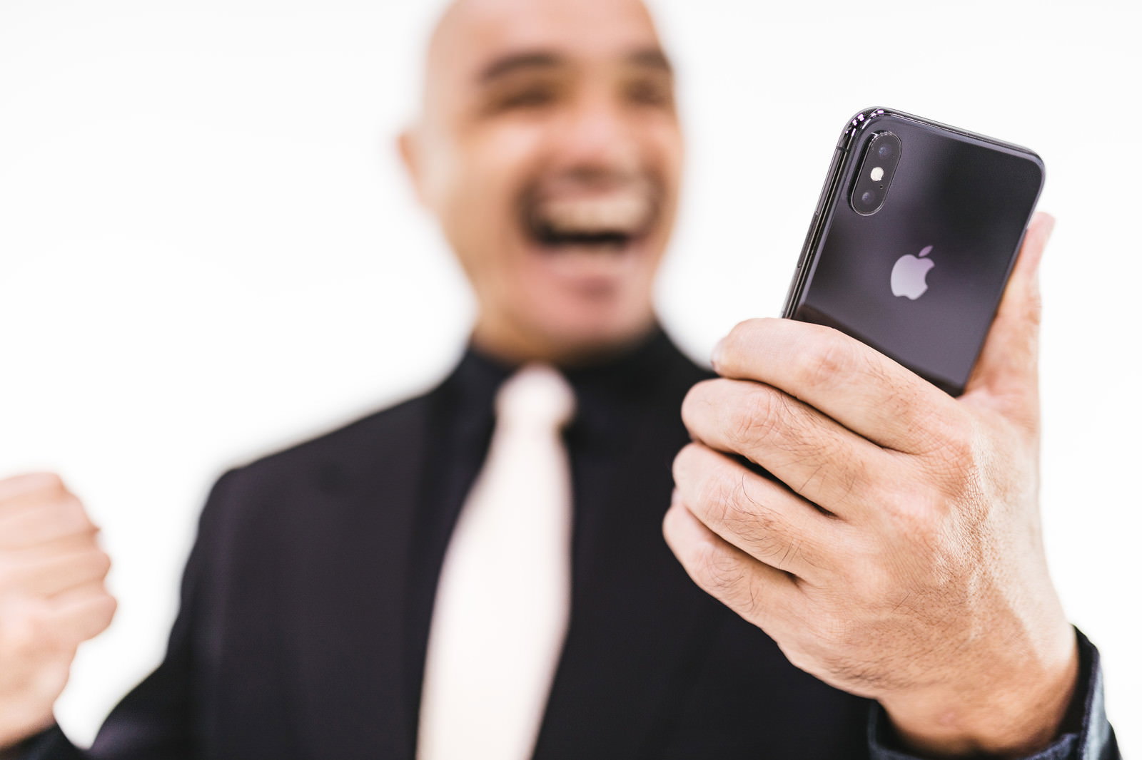 スマートフォンを見て喜ぶ表情の中年男性［モデル：よたか］